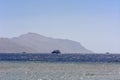 Luxurious snow-white motor yacht in the Red Sea against the blue sky and ancient high corals on the shore