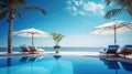 Luxurious swimming pool and loungers umbrellas near beach and sea with palm trees
