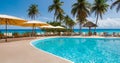 Luxurious swimming pool, sunbeds, umbrellas and palm trees near the beach and tropical sea Royalty Free Stock Photo