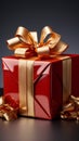 Luxurious touch: Gleaming red gift box, adorned with golden ribbon and bow.