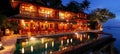 Luxurious tropical resort pool at night with sparkling lights and palm trees reflecting in water