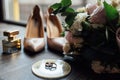 Luxurious wedding bouquet next to the rings of the bride and groom. The bride`s shoes with heels Royalty Free Stock Photo