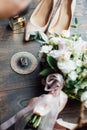 Luxurious wedding bouquet next to the rings of the bride and groom. The bride`s shoes with heels Royalty Free Stock Photo