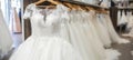 Luxurious white bridal gowns elegantly displayed on hangers in a high end boutique salon