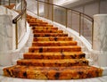 Luxurious white marble spiral staircase with modern carpet inside building. Luxurious decoration style Royalty Free Stock Photo