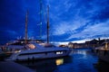 Luxurious yachts and boats in the port at night. evening, pier, sea, and sky