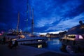 Luxurious yachts and boats in the port at night. evening, pier, sea, and sky