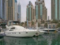 Luxurious Yachts in Front of Dubai Marina Futuristic Skyscrapers in cloudy rainy day.