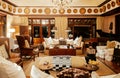 Luxury African Safari lodge interior with vintage white armchairs and sofa couch wooden table and grand piano