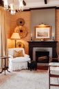 Luxury African Safari lodge living room interior with vintage white armchair, lamp, old wood table and fireplace