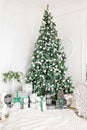 Luxury apartment decorated for christmas. Xmas tree with presents underneath in living room Royalty Free Stock Photo