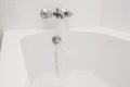 Luxury bath tub and faucet with water. Royalty Free Stock Photo