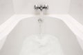 Luxury bath tub and faucet with water. Royalty Free Stock Photo