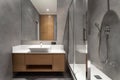 washbasin and shower in hotel bathroom with modern interior