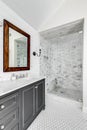 A luxury bathroom with custom tile, wood framed mirror, and shiplap wall. Royalty Free Stock Photo