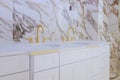 Luxury bathroom with marble white countertop faucet in washbasin expensive antique style gold plated handles Royalty Free Stock Photo