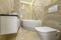 Luxury bathroom with white bathub and beige marble tiles