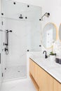 A luxury bathroom with a wood cabinet and marble walk-in shower. Royalty Free Stock Photo