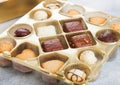 Luxury belgian chocolate and biscuit cookies selection in original golden tray and white kitchen table background