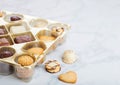 Luxury belgian chocolate and biscuit cookies selection in original golden tray and white kitchen table background