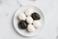 Luxury black and white Easter eggs decorated gold on plate on marble table.