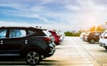 Luxury black, white and red new suv car parked on concrete parking area at factory with blue sky and clouds. Car stock for sale.