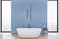 Luxury blue tile, wooden bathroom interior with bathtub, panoramic city view, daylight and other objects. Design and hotel concept