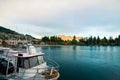 Luxury boat dock in Queenstown New Zealand tourist destination with golden sunset lights on The Remarkables mountains