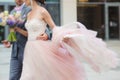 Luxury bride holding a flying dress and walking Royalty Free Stock Photo