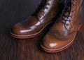 Luxury brown shoes on wood background.