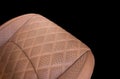 Luxury car brown leather interior. Part of brown leather car seat details with stitching isolated on black. Interior of prestige