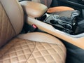 Luxury car brown leather interior. Part of brown leather car seat details with stitching isolated on black. Interior of prestige