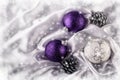 Luxury Christmas balls Silver pine cones on white satin Christmas decoration combined purple and silver colors. Royalty Free Stock Photo