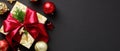 Luxury Christmas banner design. Top view gift box with red ribbon bow, gold and red baubles on black background Royalty Free Stock Photo