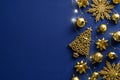 Luxury Christmas card design. Golden Xmas decorations, sparkle lights garland on dark blue background. Flat lay, top view, copy