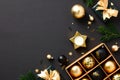 Luxury Christmas flat lay composition. Gold baubles, Xmas ornaments, gift boxes, fir branches on black background. Christmas or