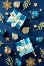 Luxury Christmas gift boxes with ribbon bow on dark blue background with snowflakes, Xmas ball ornaments, fir branches. Top view. Royalty Free Stock Photo