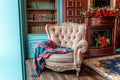 Luxury classic interior of home library. Sitting room with bookshelf, books, arm chair, sofa and fireplace Royalty Free Stock Photo