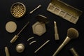 luxury cosmetics - set with golden decorative makeup products on black. top view