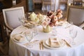 Luxury cozy autumn wedding table decoration in the restaurant. Fresh and dried flowers, roses, carnations. Beautiful table setting