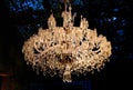 Luxury crystal chandelier shining on dark background.