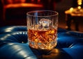 Luxury crystal glass of whiskey with ice on blue leather sofa in restaurant lounge.Macro.AI Generative Royalty Free Stock Photo