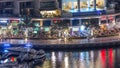Luxury Dubai Marina canal with passing boats and promenade night timelapse, Dubai, United Arab Emirates Royalty Free Stock Photo