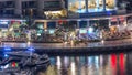 Luxury Dubai Marina canal with passing boats and promenade night timelapse, Dubai, United Arab Emirates Royalty Free Stock Photo