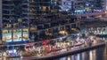 Luxury Dubai Marina canal with passing boats and promenade night timelapse, Dubai, United Arab Emirates Royalty Free Stock Photo