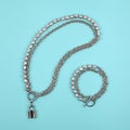 Luxury elegant baroque pearl necklace with lock shape pendant and bracelet on bright turquoise textured background