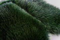 Luxury and elegant fluffy clothes. Dyed furry coat in green color, close up.