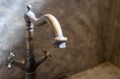 Luxury faucet with golden sink on the raw concrete counter in vintage bathroom Royalty Free Stock Photo