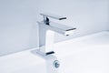 Luxury faucet mixer and white towel on a white sink in a beautiful gray bathroom. Sanitary prevention antivirus concept