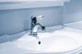 Luxury faucet mixer and white towel on a white sink in a beautiful gray bathroom. Sanitary prevention antivirus concept